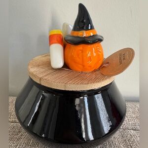 East West 11 oz candle with Halloween ceramic decor on wooden lid.